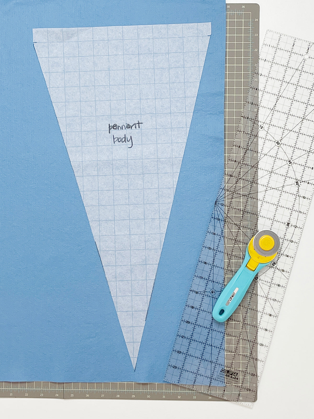 Bird's Eye view of a tracing paper triangle laid on light blue felt.