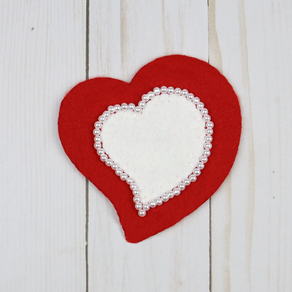Red Heart with white faux pearl beading around a smaller white heart