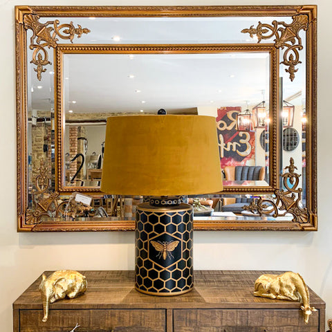 Bee lamp and peering animal accent pieces in front of a feature mirror.