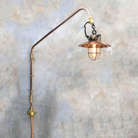 steampunk wall lighting with a copper swing arm fixture and copper and iron pendant light