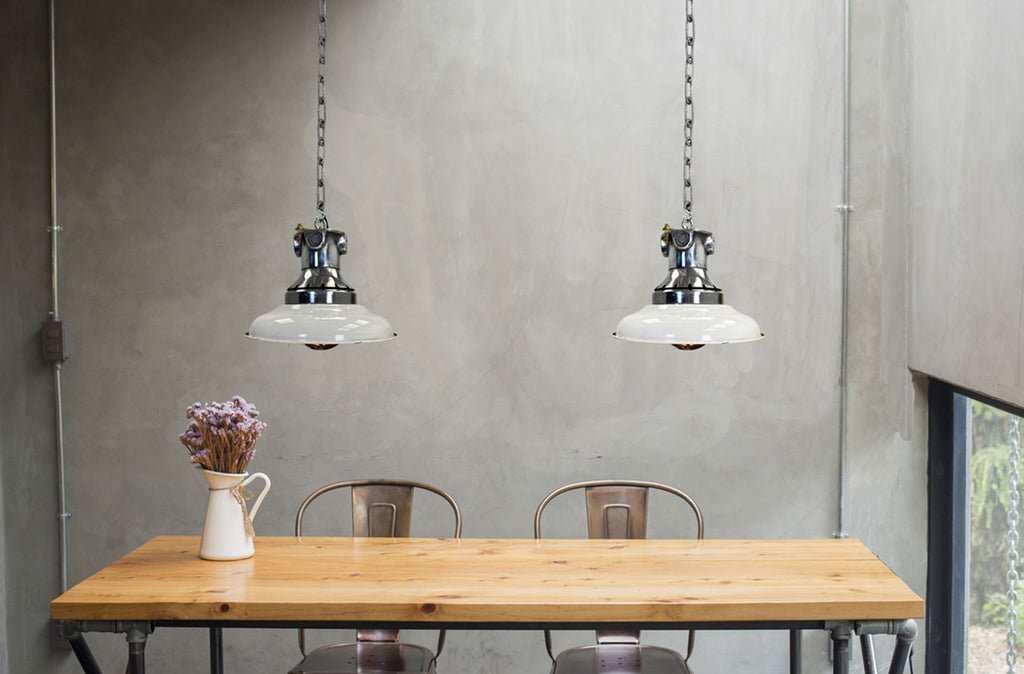 Vintage lighting over a rustic dining table in an industrial style kitchen diner