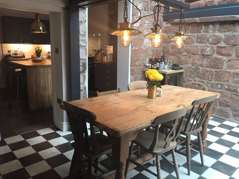 steampunk lighting ideas for the home interior. Three steampunk pendant lights hang over a dining table in a kitchen diner