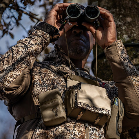 man using binoculars on a hunt