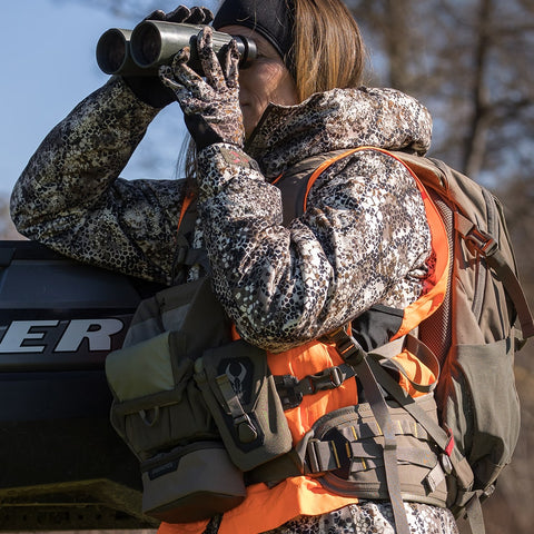 female hunter using binoculars