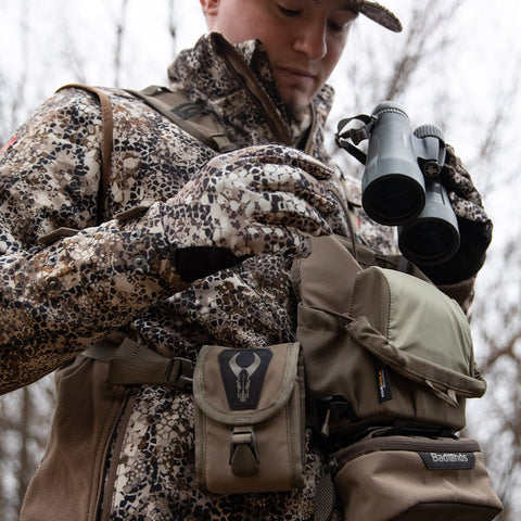 hunter pulling binoculars out of harness