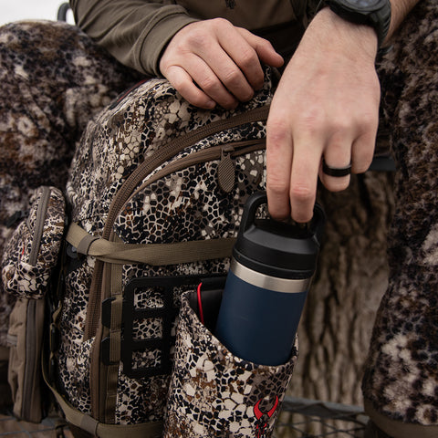 hunter pulling water bottle out of pouch on Badlands pack
