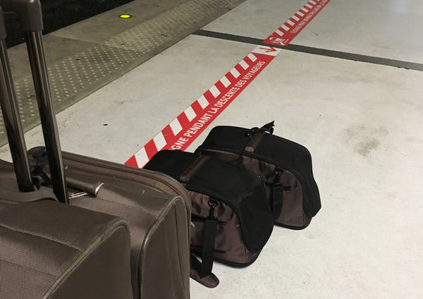 Cats in Sleepypods waiting on the train platform with their humans at Paris Charles de Gaulle Train Station