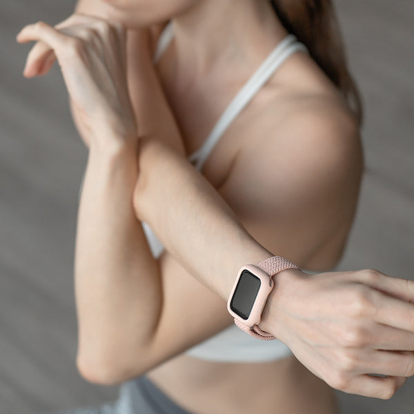 ピンクのApple WatchブレイデッドバンドとApple Watchケースを装着したApple Watchをつけた女性がストレッチをしている