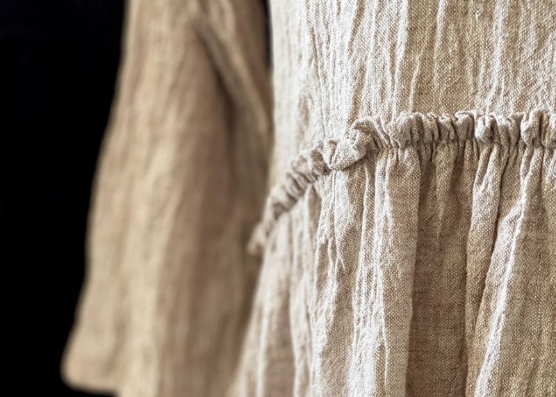 Close up of the gathered waist of a linen dress