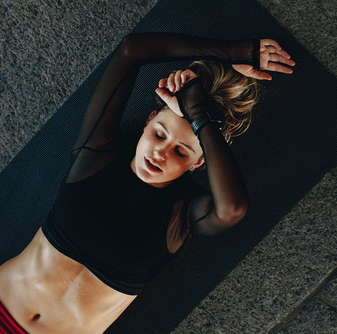 Woman lying on back during exercise, preparing for next rep