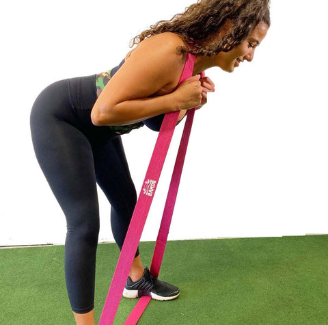 Woman using X Bands to exercise her glutes.