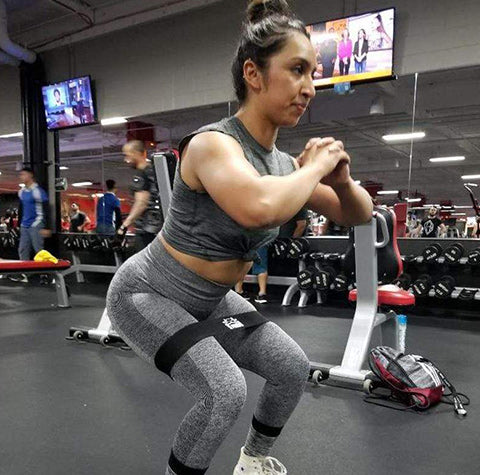 Woman performing a classic squat movement in a gym