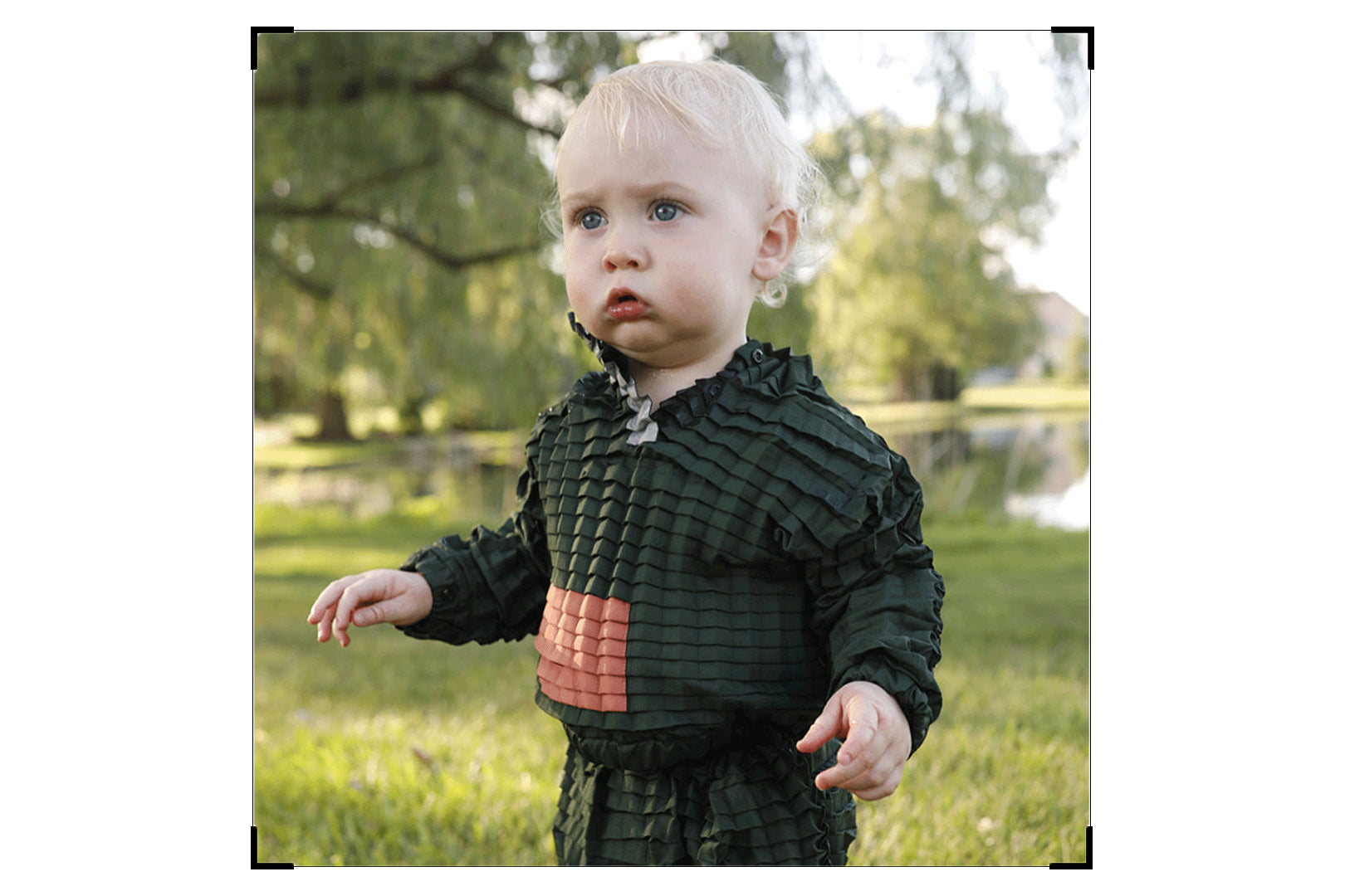 A child wearing Petit Pli Green Ore Contrast Suit 