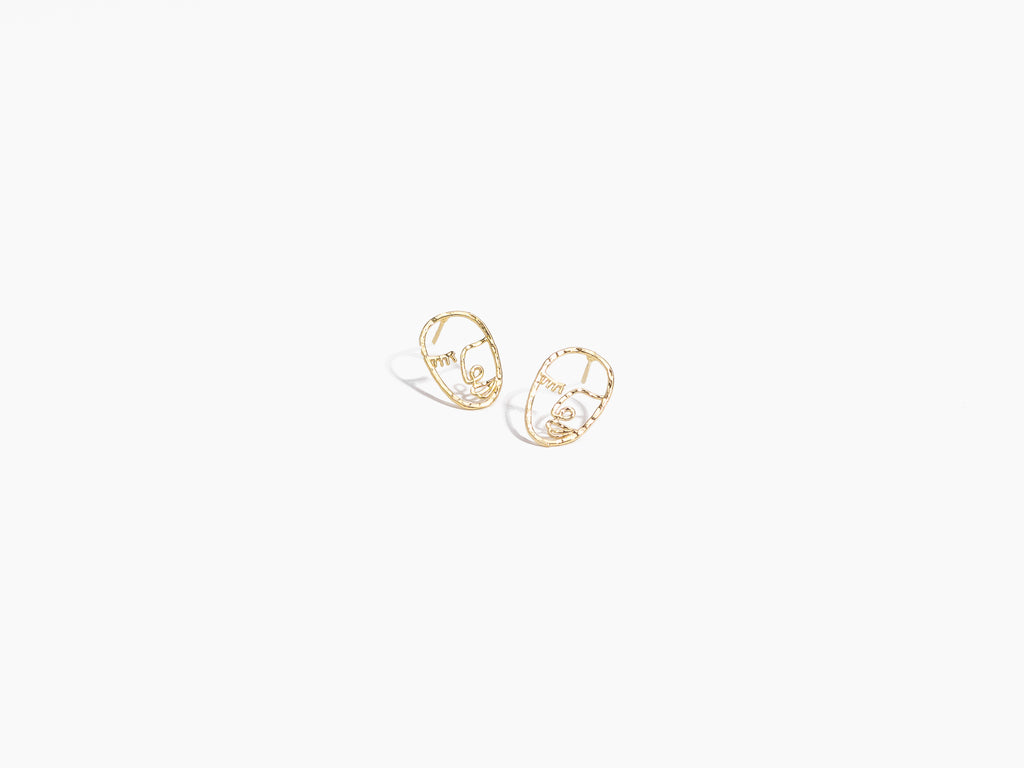 Pair of Katie Dean Jewelry hypoallergenice Artist Face Studs with delicate handmade gold construction and nickel free, laid against a white background.
