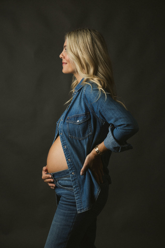 Katie Dean-Tam Maternity Shoot wearing blue jeans and a button down blue jean shirt showing her beautiful baby bump