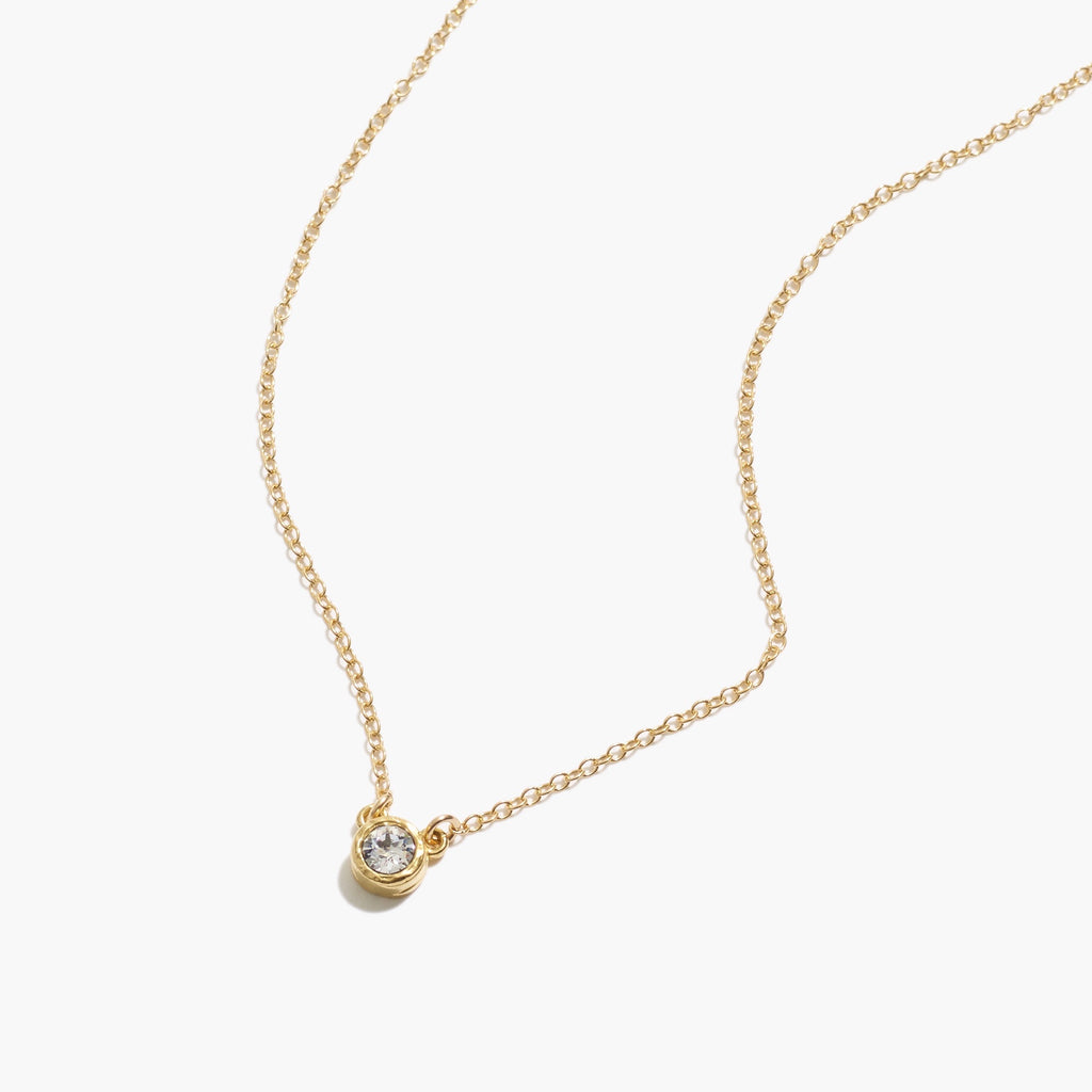 Dainty gold Birthstone Necklace by Katie Dean Jewelry laying on a white background.