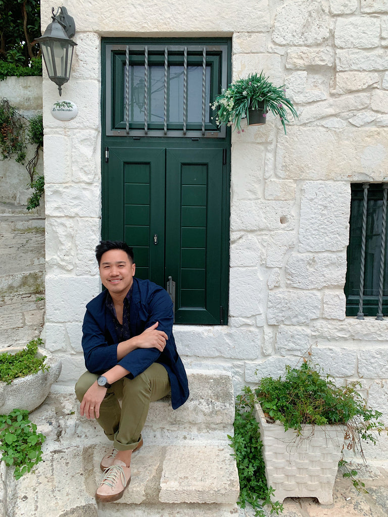 Puglia Italy trip 2019. My husband Jon sitting on front porch of the white washed home in Ostuni with forest green door and lantern