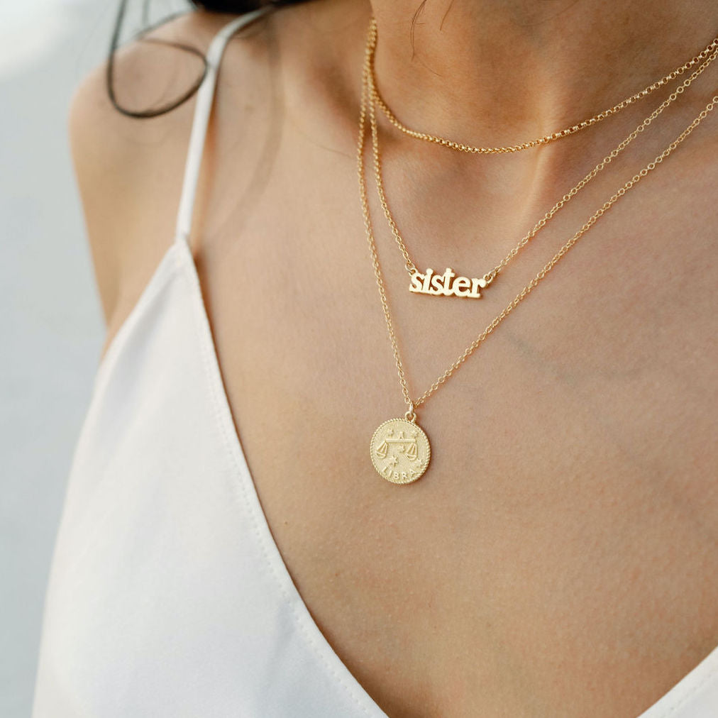 Dainty delicate gold Sister Necklace layered up with other gold pieces by Katie Dean Jewelry, made in America.