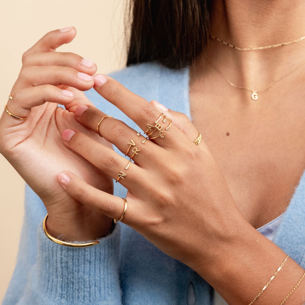 Model wearing the Initial Ring with other dainty gold stacking rings by Katie Dean Jewelry