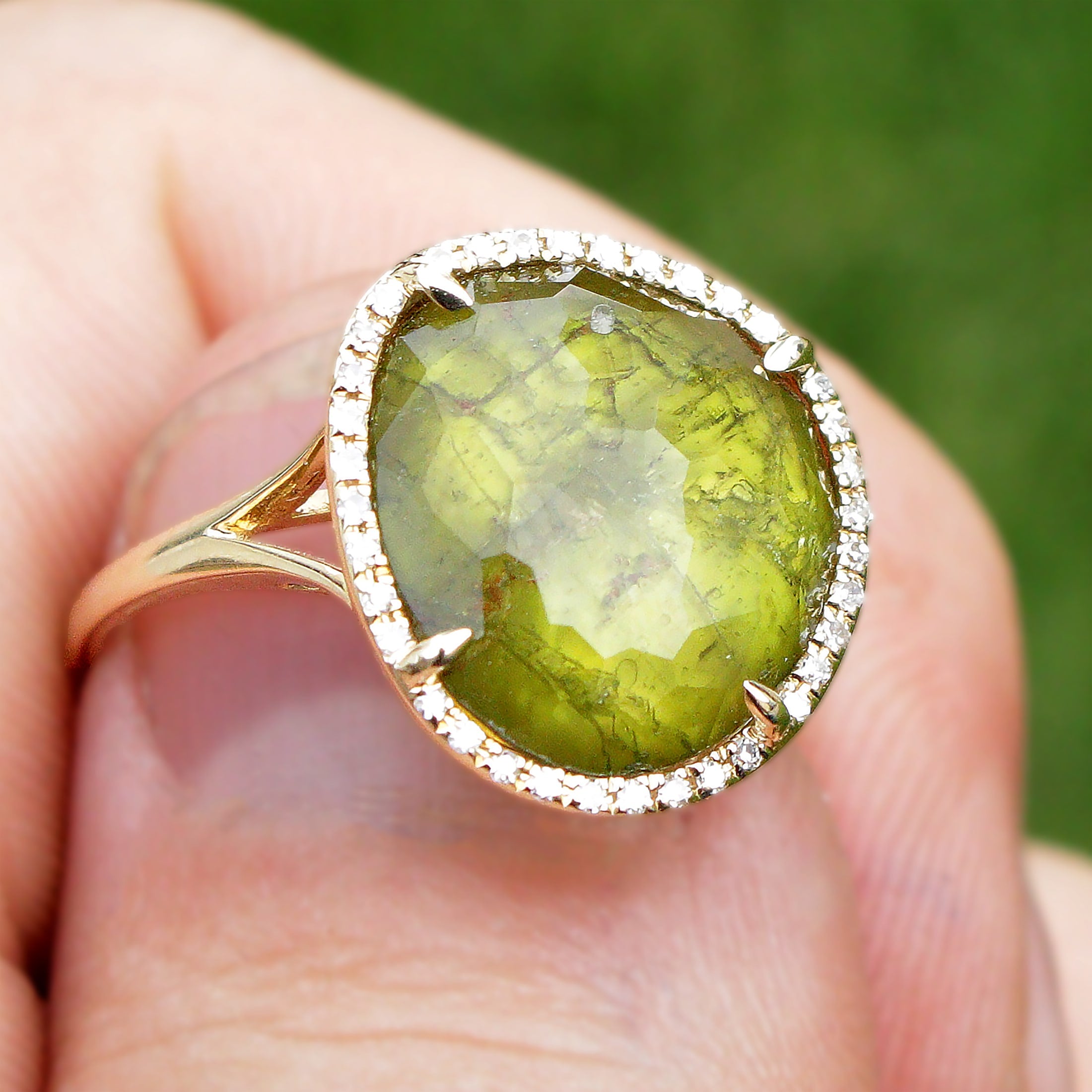 Green tourmaline ring with halo and inclusions.