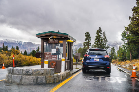 A car stops at a national park entrance station to pay entrance fees.