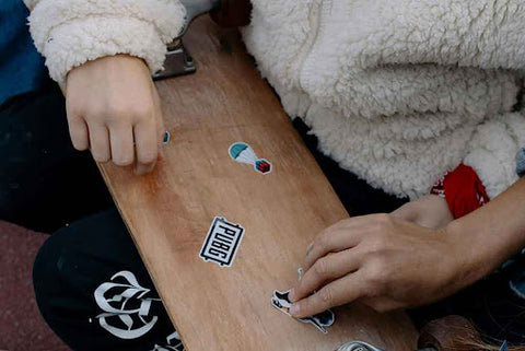 closeup of applying stickers to skateboard