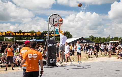 Person dunking a basketball at a festival.