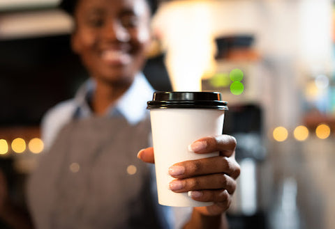 woman holding white coffee cup