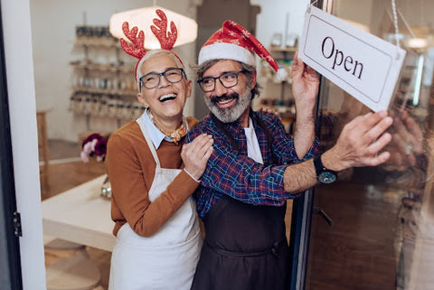 older man and woman storeowners in festive attire opening business