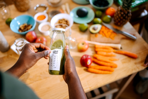 applying label to health drink bottle