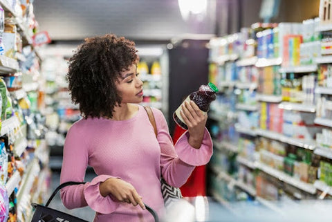 woman looking at kombucha at the grocery store