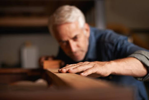 man examining texture of wood surface
