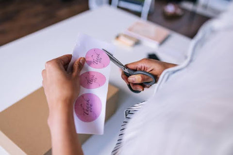 woman cutting roll sticker with scissors