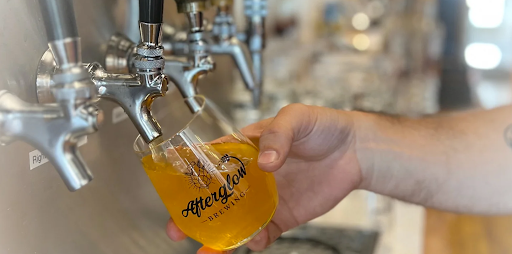 hand pouring beer from a line of taps