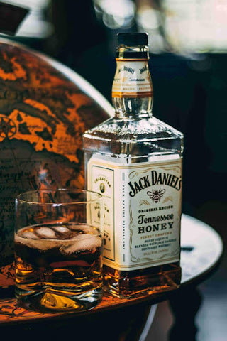 honey whiskey bottle with glass