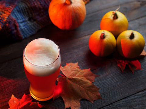 Glass of beer and pumpkins on a table