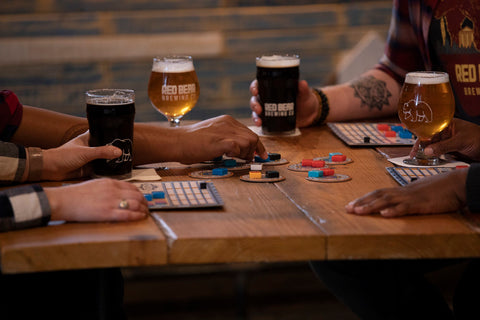 People playing games at table with beers.