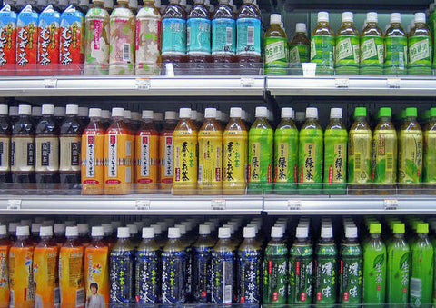Assorted iced teas on a refrigerated shelf in a store.