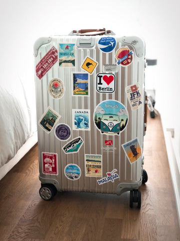 Luggage covered in stickers.