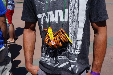 Man wearing pretzel necklace at festival.