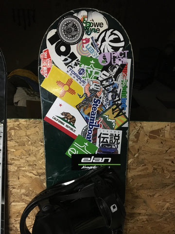 Snowboard covered in stickers.
