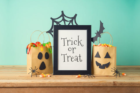 Trick or Treat sign on table with other halloween decor.