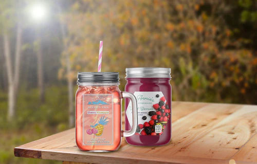 Two mason jars with juice and jelly on a picnic table