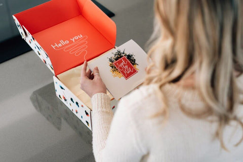Woman opening PR box that says "hello you."