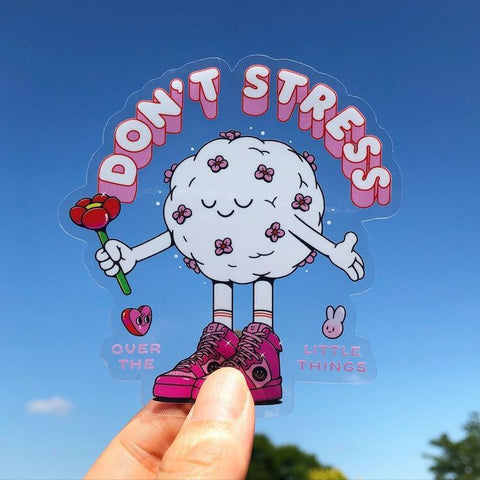 Clear "don't stress" sticker held in the air.