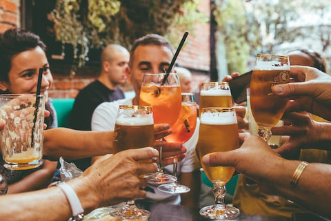 Group of people clinking glasses together, cheers.