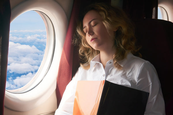 A woman falls asleep on a plane