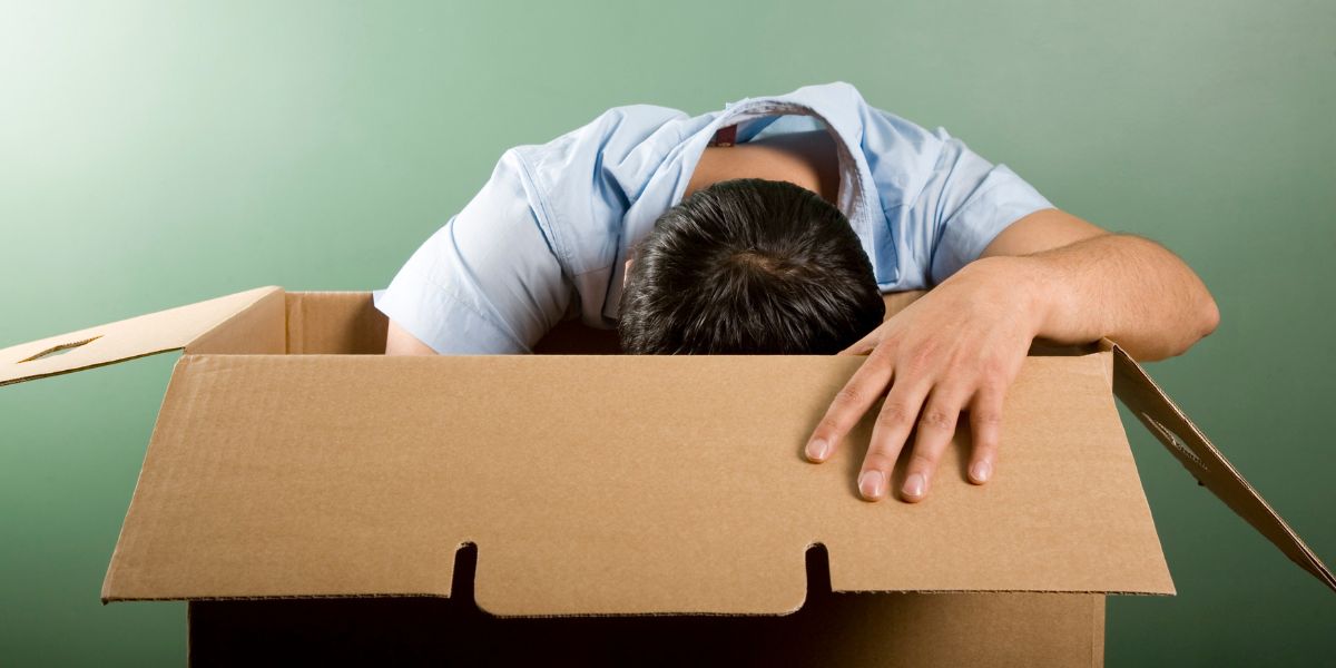 Man Searching At Bottom Of Giant Brown Cardboard Box