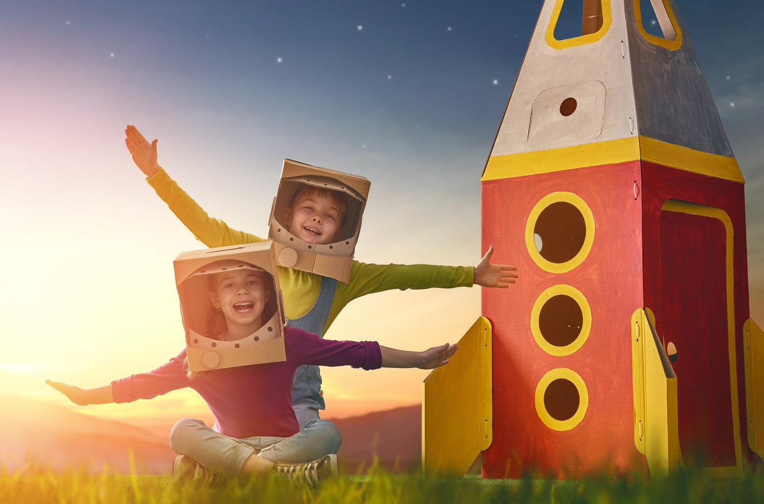 children with a rocket and helmets made from cardboard boxes