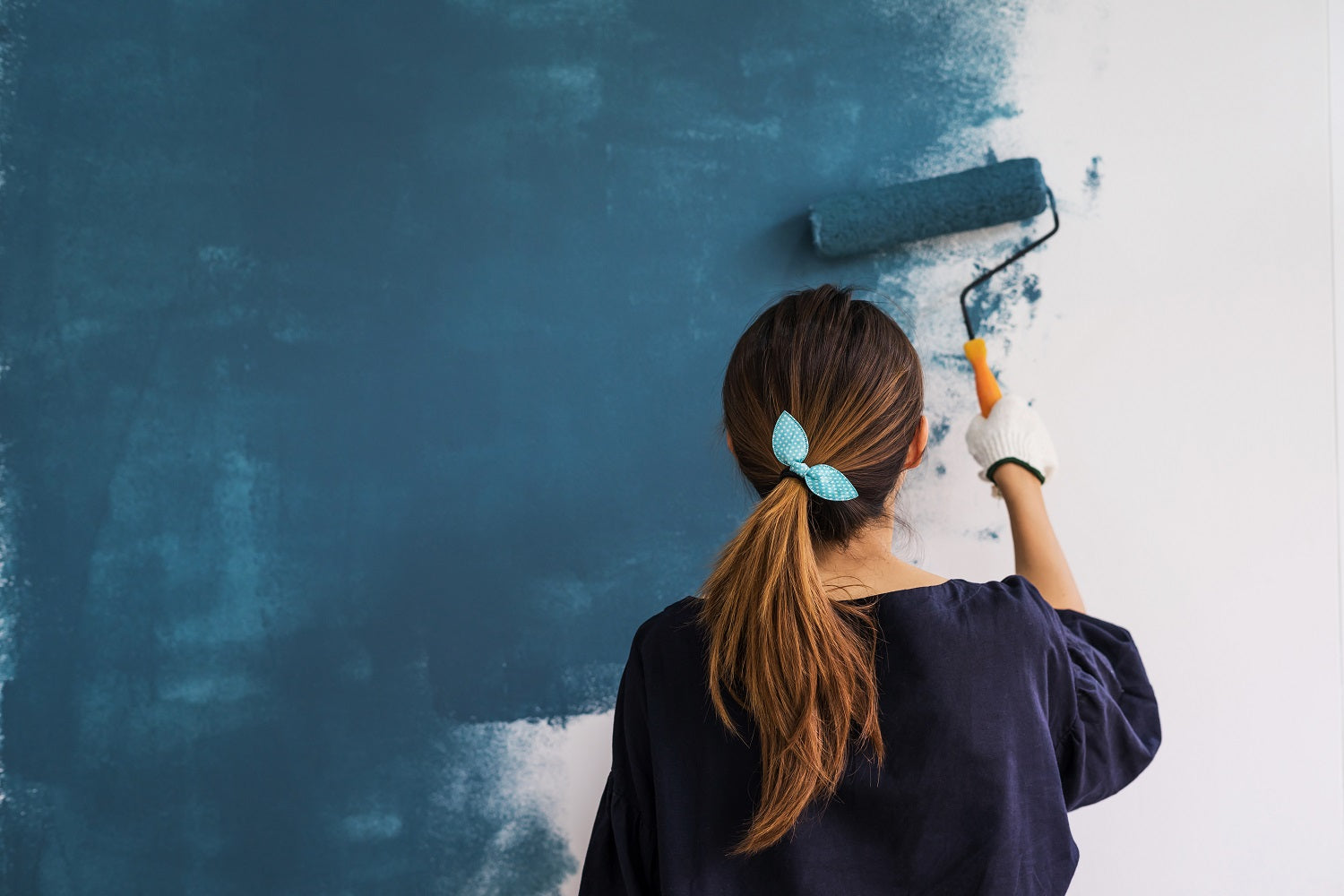 lady painting a wall blue